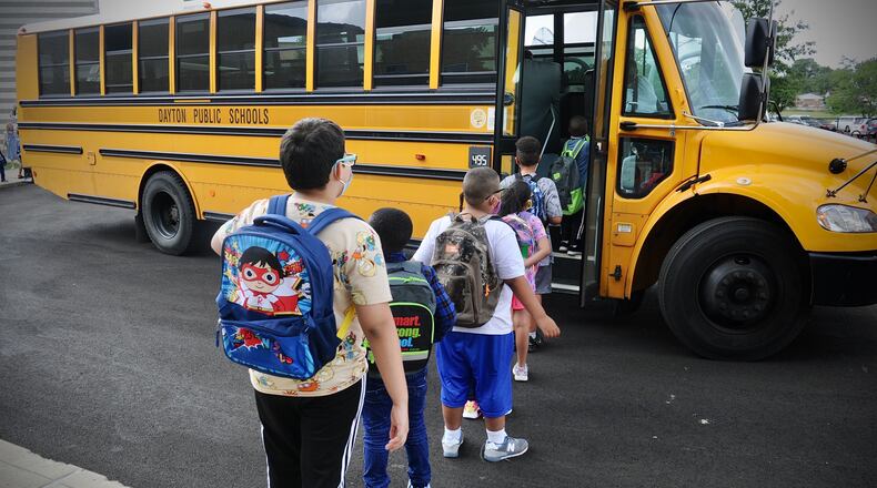 Students at Eastmont elementary in Dayton wait to board the bus at the end of the first day of school on Wednesday Aug. 18, 2021. MARSHALL GORBY\STAFF