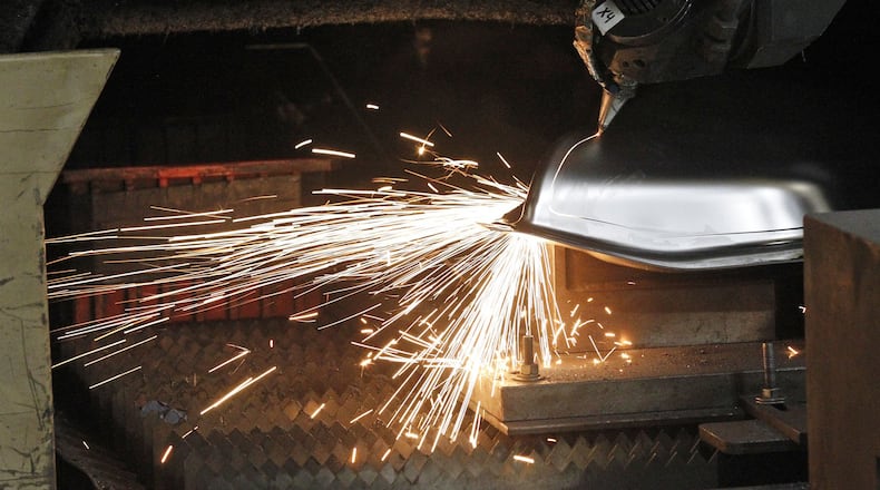 A CNC laser cutting machine cuts a part at Staub Manufacturing Solutions of Dayton. Co-owner Steve Staub credits last-year’s tax cut with jump-starting the economy. TY GREENLEES / STAFF