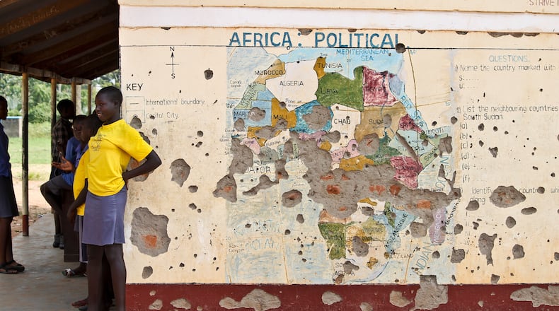 In this photo taken Nov. 15, 2016, students line up outside a classroom with a map of Africa on its wall, in Yei, in southern South Sudan. (AP Photo/Justin Lynch, file)