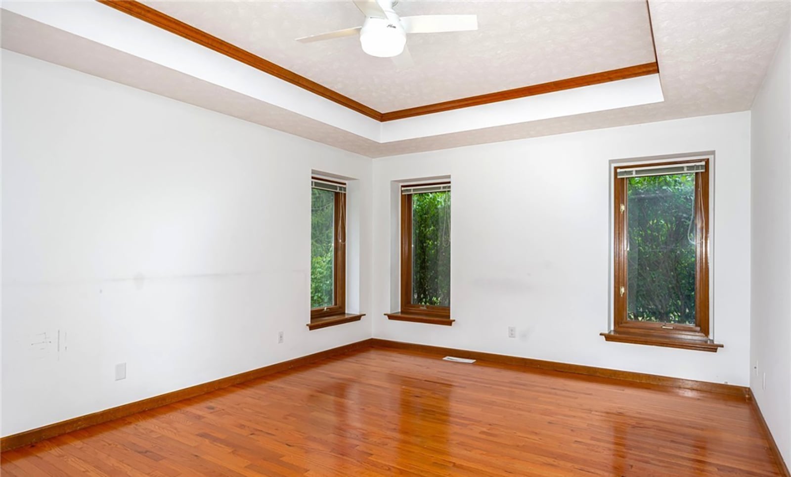 The primary bedroom suite has a tray ceiling and ceiling fan, hardwood floors and an ensuite bathroom with two showers and two toilets. CONTRIBUTED