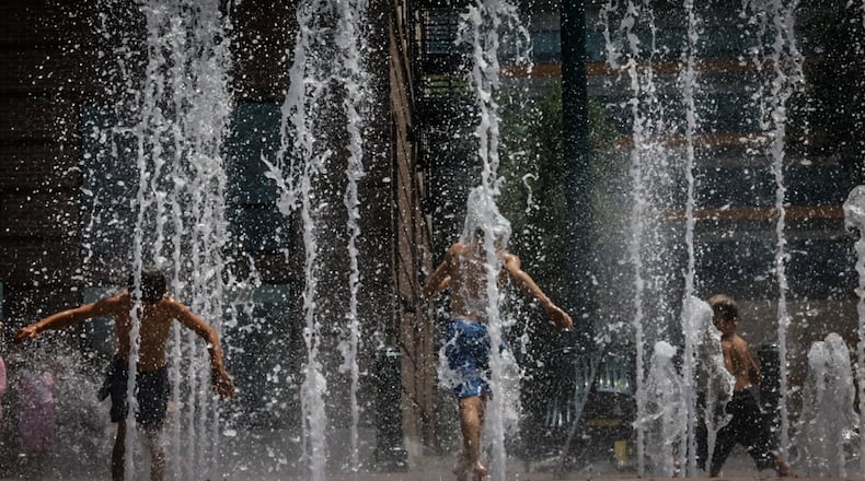 Near 90-degree temperature on Wednesday July 5, 2023 caused area children and adults to the RiverScape MetroPark fountain to cool off. JIM NOELKER/STAFF