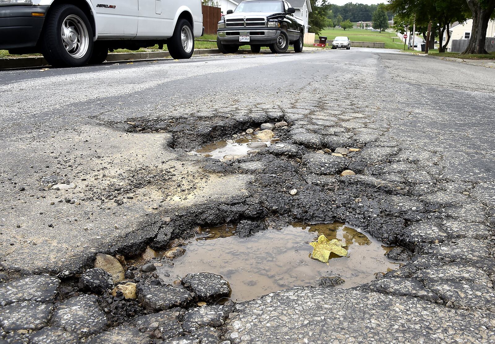 Potholes along Rodgers Drive in Springfield. The City of Springfield will ask voters to approve a 5-year, quarter-percent income tax increase that will help fix neighborhood streets. Business leaders are opposed to the plan to raise the income tax and believe the city should find the money to fix streets without raising taxes. Bill Lackey/Staff