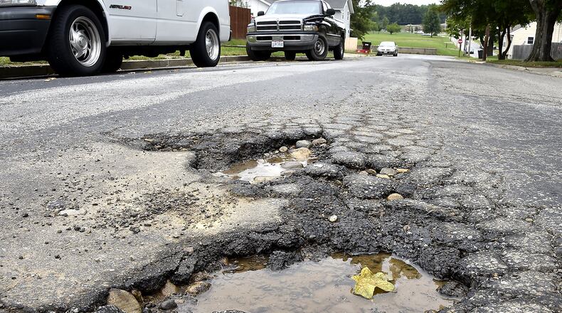 Potholes along Rodgers Drive in Springfield. The City of Springfield will ask voters to approve a 5-year, quarter-percent income tax increase that will help fix neighborhood streets. Business leaders are opposed to the plan to raise the income tax and believe the city should find the money to fix streets without raising taxes. Bill Lackey/Staff