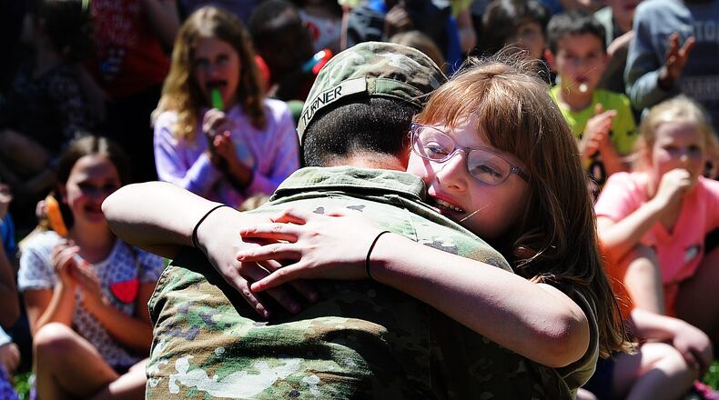 Oakwood Elementary third grader Maddisyn Beaty hugs her father, Private Jacob Turner, after he surprised her at her school Thursday, April 18, 2024. Turner had been gone for seven months for training. MARSHALL GORBY\STAFF