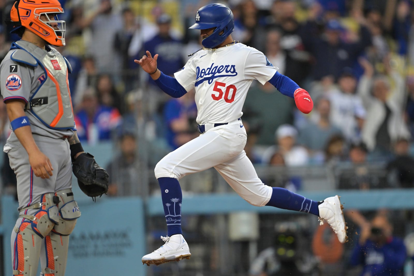 Los Angeles Dodgers' Mookie Betts (50) scores past New York Mets catcher Francisco Alvarez during the first inning of a baseball game Tuesday, June 3, 2025, in Los Angeles. (AP Photo/Jayne Kamin-Oncea)