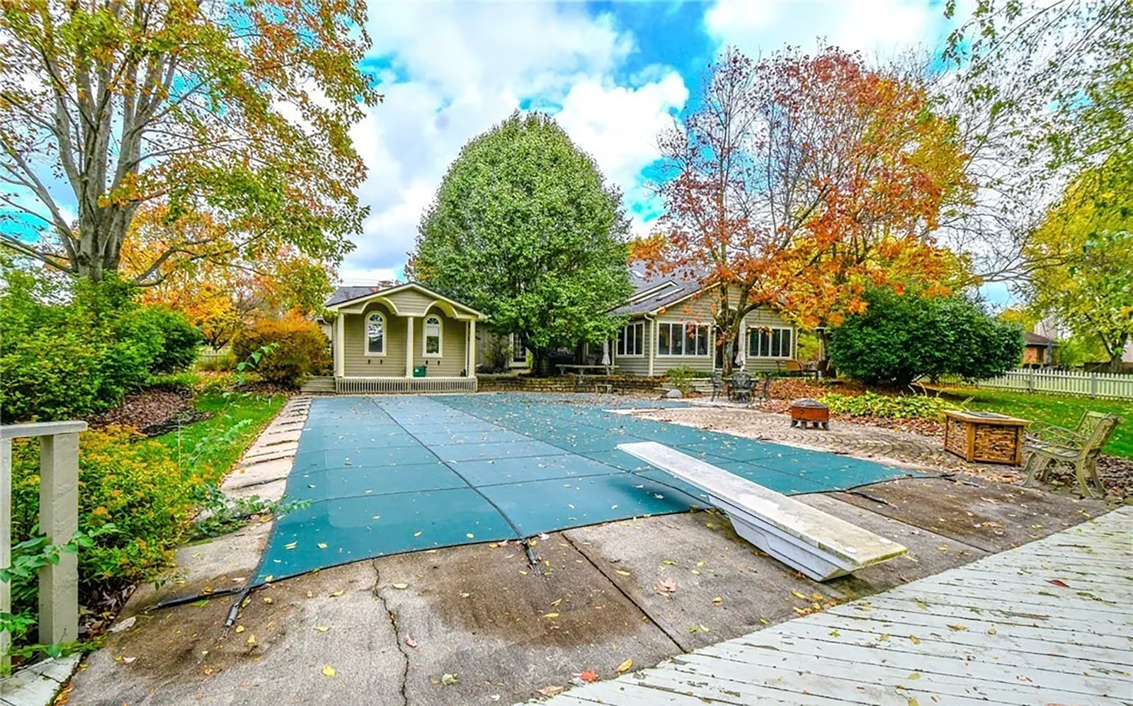 The backyard features an inground pool with diving board and concrete patio surrounding it. There is also a dedicated pool house. CONTRIBUTED