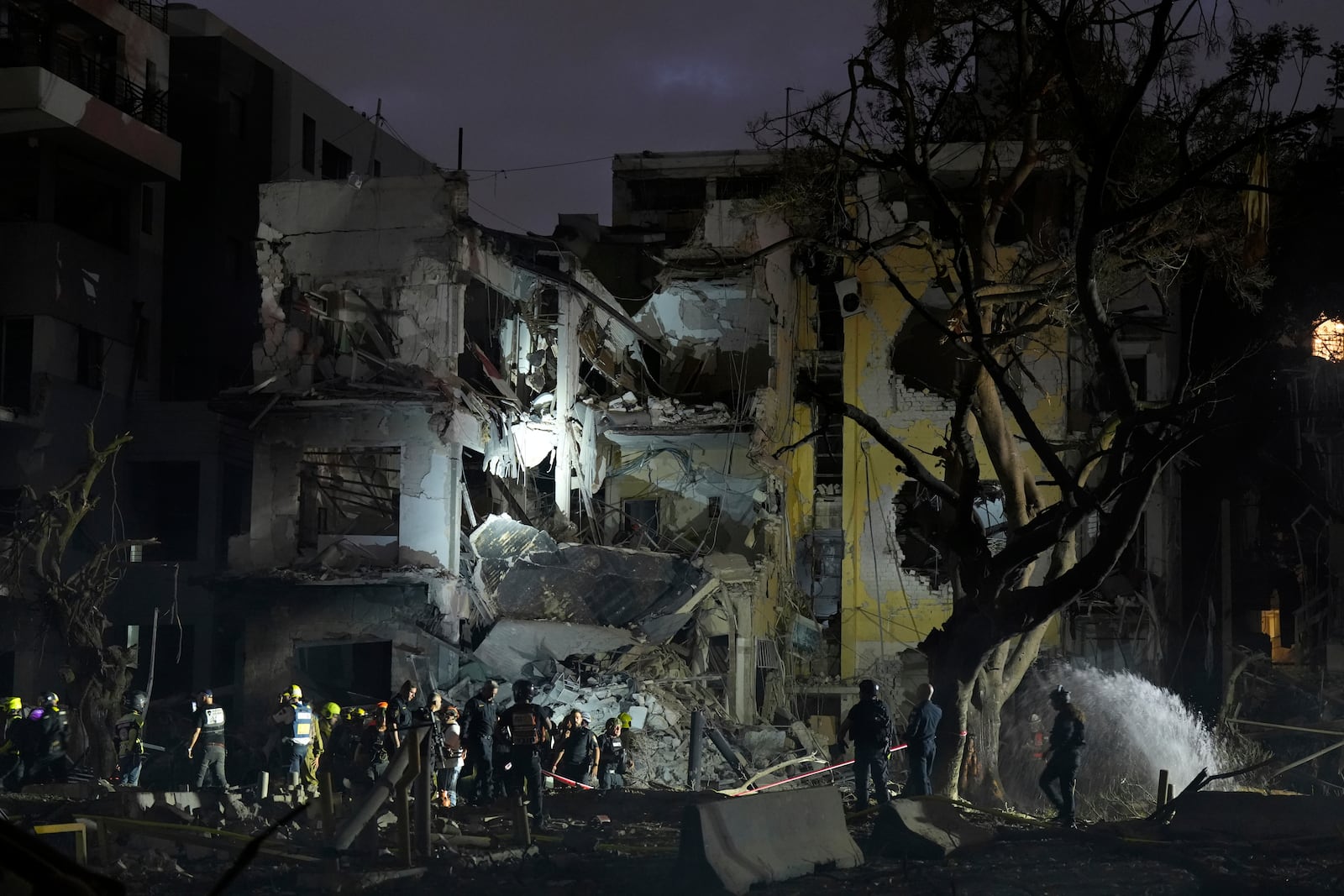 Rescue team work at the site where a missile launched from Iran struck Tel Aviv, Israel, Monday, June 16, 2025. (AP Photo/Baz Ratner)