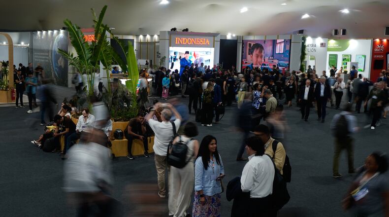 People walk outside the Indonesia Pavilion at the COP30 U.N. Climate Summit, Monday, Nov. 10, 2025, in Belem, Brazil. (AP Photo/Fernando Llano)