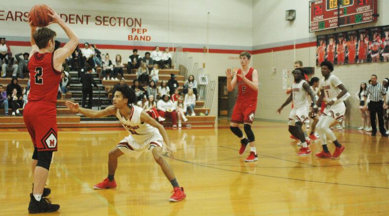 Madison’s Tristan Sipple (2) looks toward teammate Grant Whisman (5) as Northridge’s Jared Lewis (13) applies defensive pressure during Saturday night’s game in Harrison Township. Madison won 62-51. RICK CASSANO/STAFF