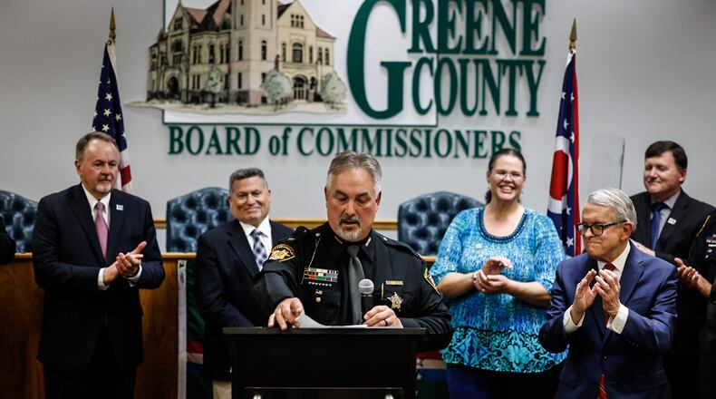 Greene County Sheriff Scott Anger talks about former sheriff Gene Fischer at the Greene County Board of Commissioners Friday, April 21, 2023. Ohio Gov. Mike DeWine, right, toured the Greene County Jail and announced a $15 million grant to support construction of a new jail. JIM NOELKER/STAFF