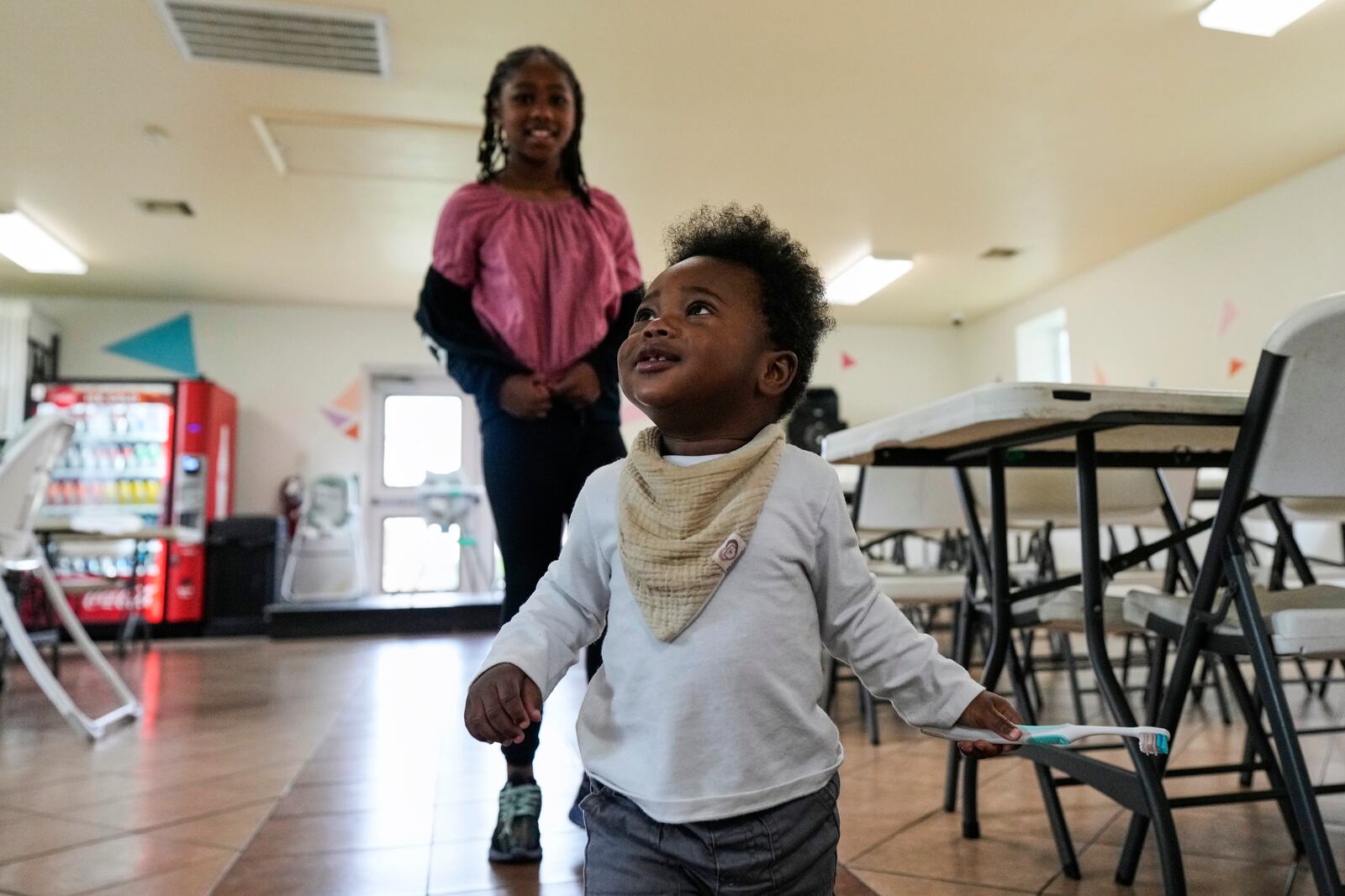 Legend Angelle, 1, and his sister, Hailey Robinson, 8, play in the dining area at Mission of Yahweh women's shelter on Tuesday, April 1, 2025, in Houston. (AP Photo/Ashley Landis)