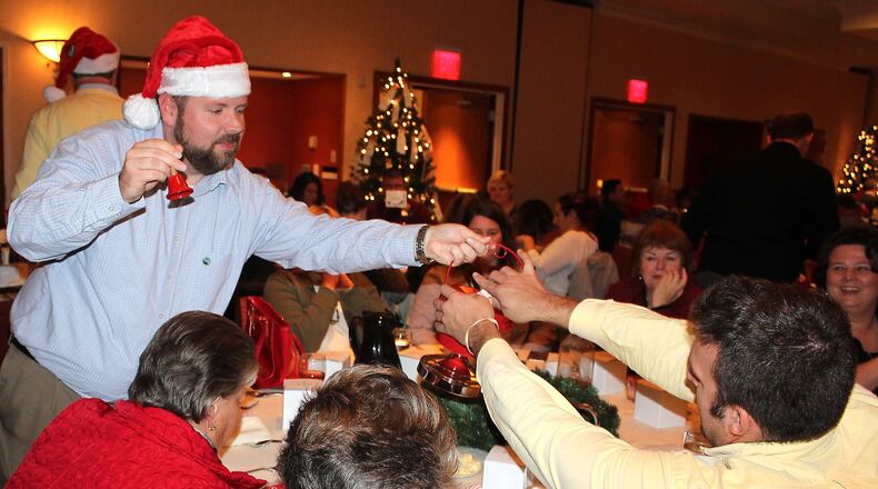 Jason Hill with Security National Bank collects money from fellow employees to start The Salvation Army Red Kettle campaign. JEFF GUERINI/STAFF
