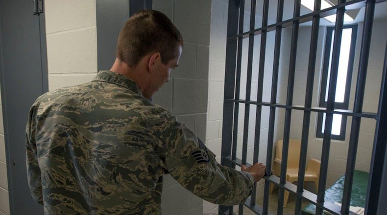 U.S. Staff Sgt. Justin Lamey, 88th Security Forces Squadron operations support NCO, opens the door to the 88 SFS confinement facility at Wright-Patterson Air Force Base June 27. Inmates are housed up to one year, depending on the duration of their confinement period, or until ready for transfer to an alternate confinement. (U.S. Air Force photo/Michelle Gigante)