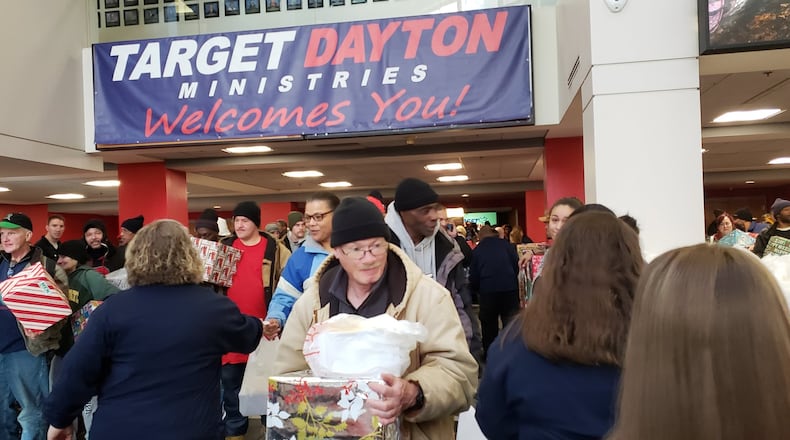 Target Dayton Ministries held its Christmas service at the Dayton Convention Center Wednesday, Dec. 25, 2019, and volunteers greeted attendees as they entered the venue, then worked to distribute 2,200 box lunches and gift boxes as they exited. ERIC SCHWARTZBERG/STAFF