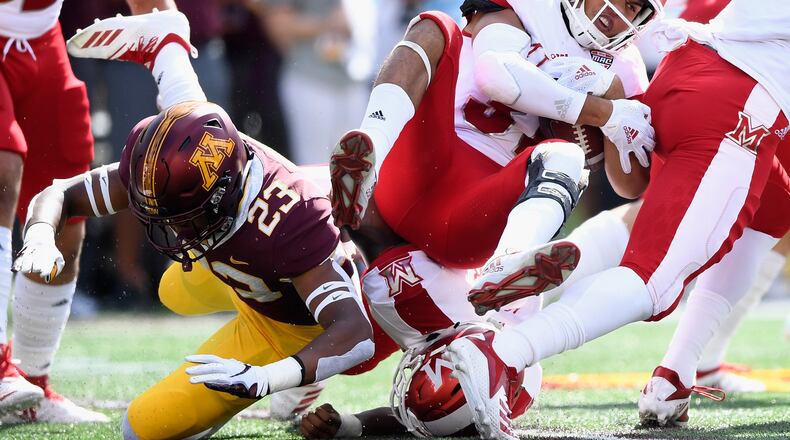 Jordan Howden of Minnesota (left) tackles Maurice Thomas of Miami on the opening kickoff return of the game at TCF Bank Stadium in Minneapolis. (Photo by Hannah Foslien/Getty Images)