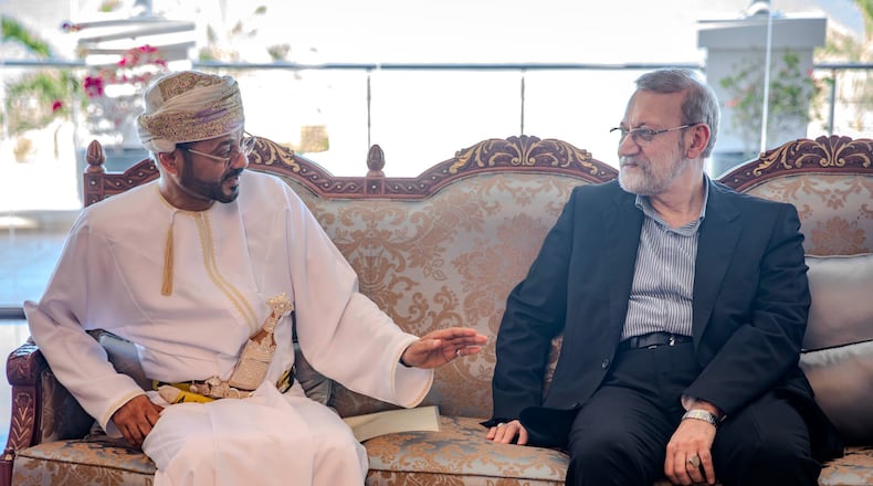 In this photo released by Iran's Supreme National Security Council office, Secretary of the Supreme National Security Council Ali Larijani, right, listens to Omani Foreign Minister Badr al-Busaidi during their meeting in Muscat, Oman, Tuesday, Feb. 10, 2026. (Erfan Kouchari/Iran's Supreme National Security Council Office via AP)