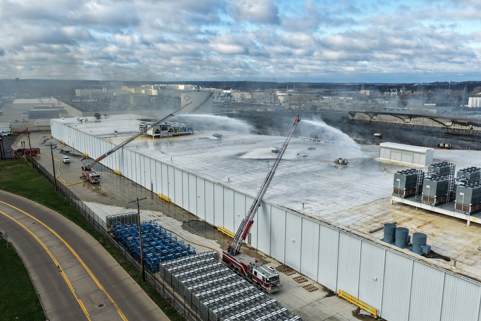 Morning crews work to extinguish remaining flames at the Fuyao Glass America plant in Moraine following a large fire. NICK GRAHAM / STAFF
