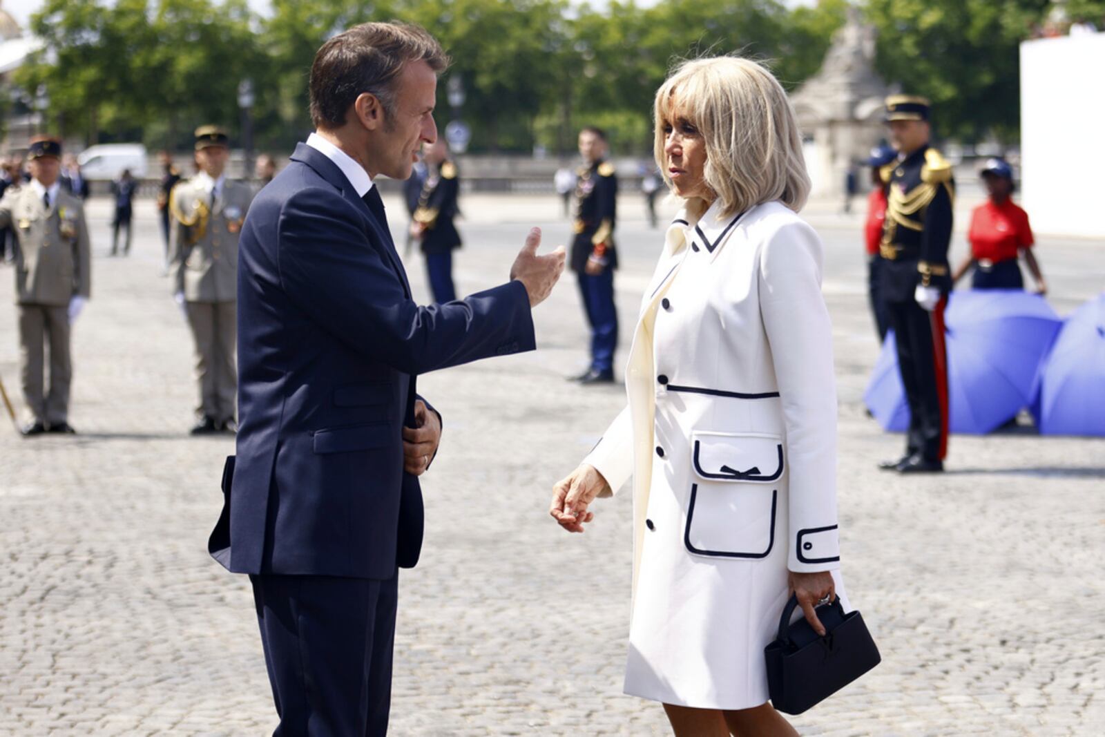 FILE - French President Emmanuel Macron and his wife Brigitte Macron as they leave the Bastille Day military parade on the Champs-Elysees avenue, Monday July 14, 2025. (Mohammed Badra, Pool via AP, File)