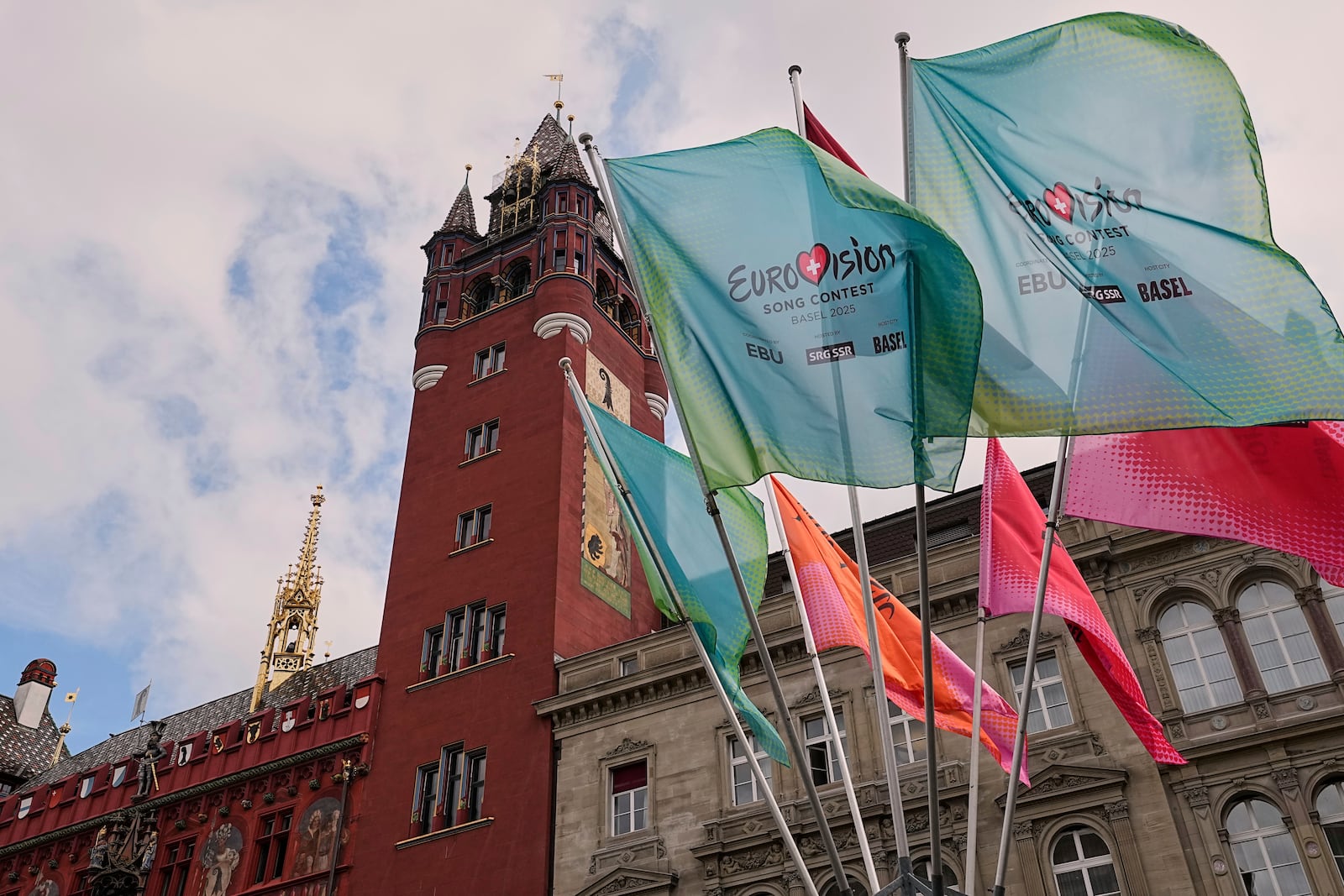 Eurovision flags wave in front of the 500-year-old Basel Town Hall in the city center ahead of the first semi-final of the 69th Eurovision Song Contest, in Basel, Switzerland, Tuesday, May 13, 2025. (AP Photo/Martin Meissner)
