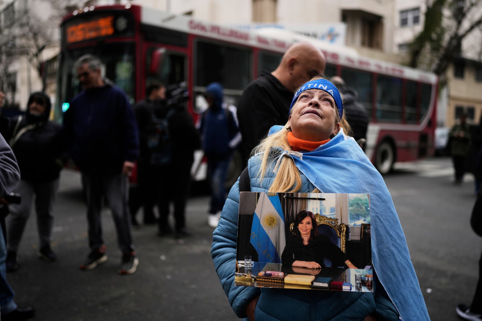 Norma Rivas, a supporter of former President Cristina Fernandez, holds a photo of the former president outside Fernandez's home after the nation's Supreme Court upheld her corruption conviction in Buenos Aires, Argentina, Tuesday, June 17, 2025. (AP Photo/Natacha Pisarenko)