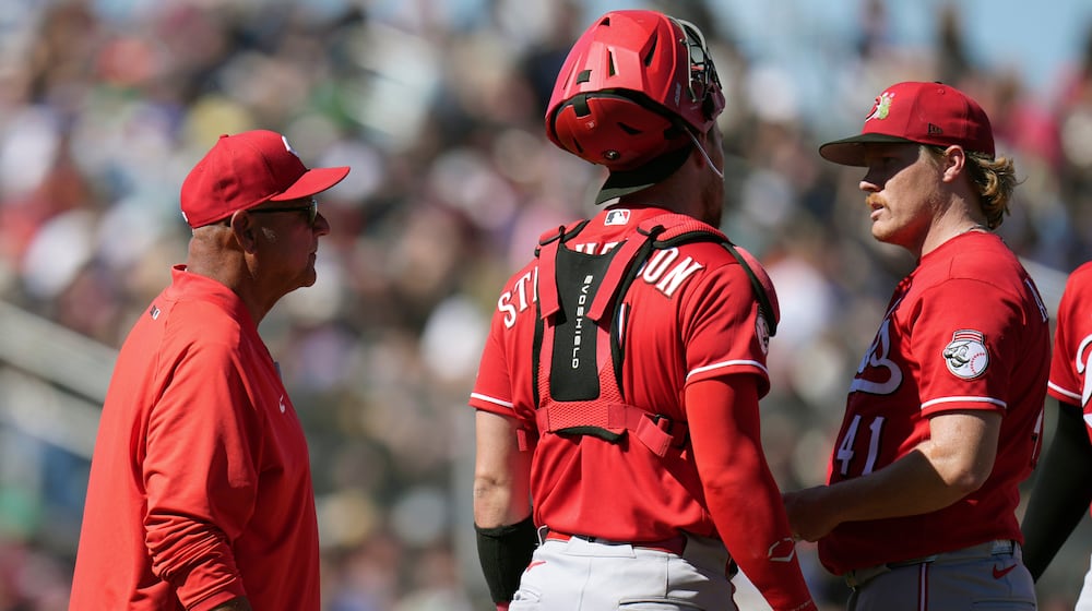 Cincinnati Reds manager Terry Francona, left, arrives at the pitcher's mound to replace Reds starting pitcher Andrew Abbott (41) as Reds catcher Tyler Stephenson looks on during the third inning of a spring training baseball game Friday, March 6, 2026, in Scottsdale, Ariz. (AP Photo/Ross D. Franklin)