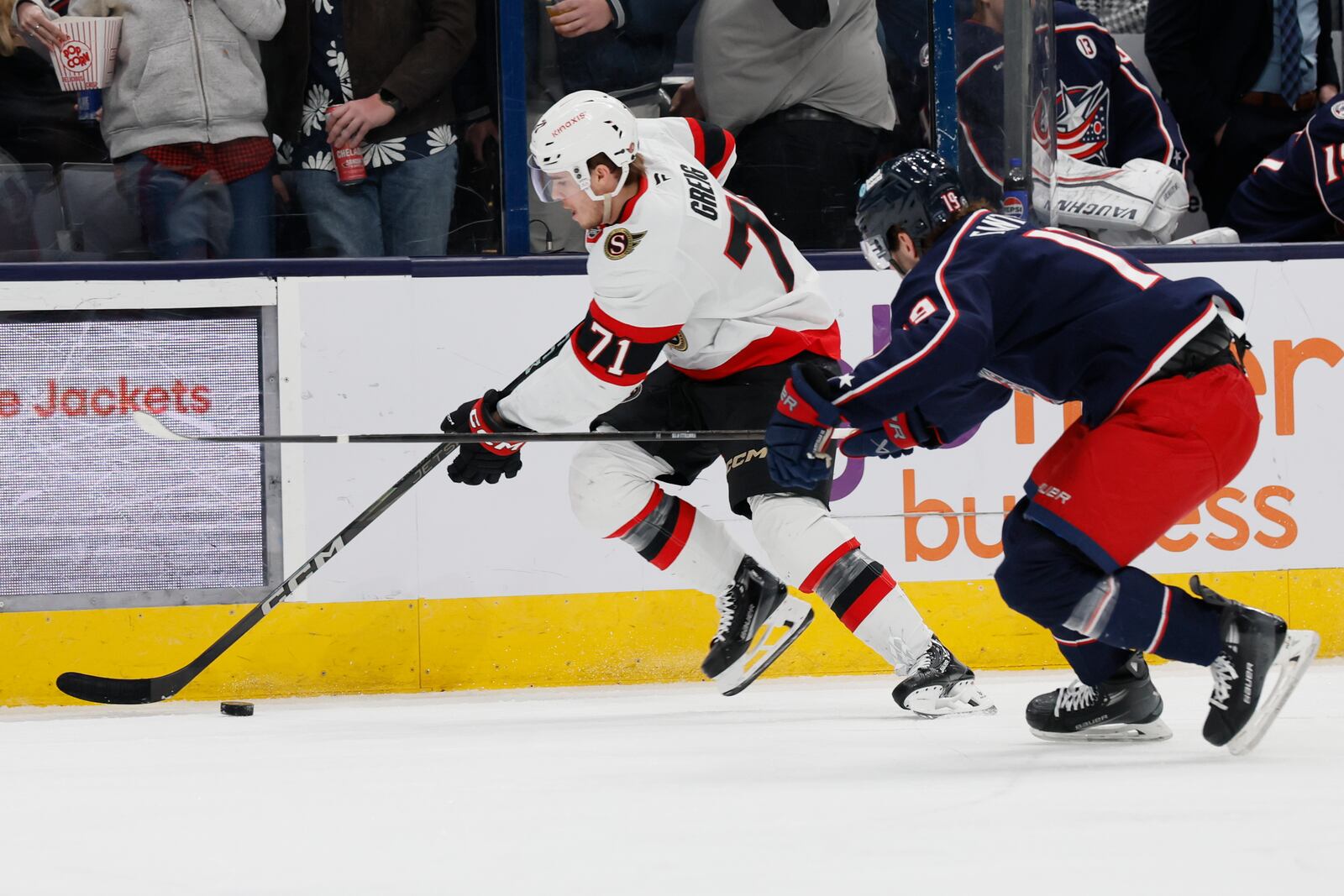 Ottawa Senators' Ridly Greig, left, carries the the puck along the boards as Columbus Blue Jackets' Adam Fantilli defends during the first period of an NHL hockey game Tuesday, April 8, 2025, in Columbus, Ohio. (AP Photo/Jay LaPrete)