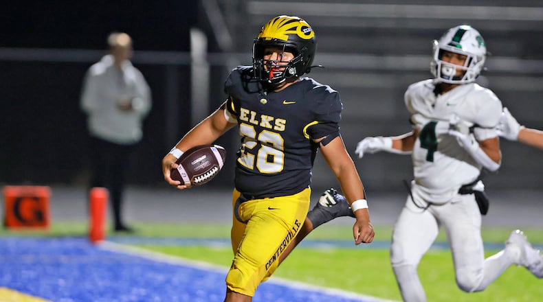 Centerville's Parker Johnson carries the ball for a  touchdown against Dublin Coffman during Friday's playoff game at Springfield. BILL LACKEY/STAFF