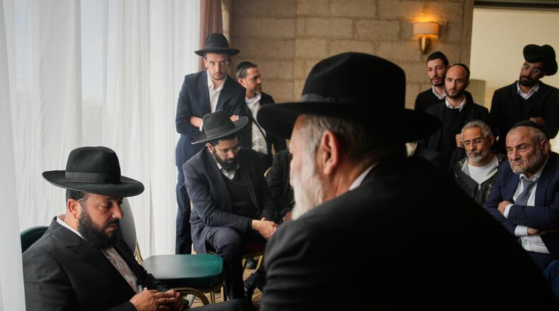 Friends and relatives comfort Yitzhak Biton, left, whose three children, Yaakov, Avigail and Sarah, were killed earlier this week when an Iranian missile struck their home in the city of Beit Shemesh, Jerusalem, Thursday, March 5, 2026. (AP Photo/Ohad Zwigenberg)