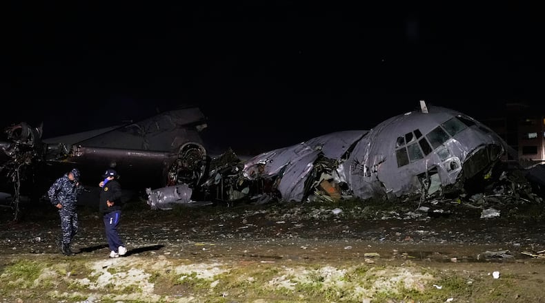 Police stands next to a plane that crashed in El Alto, Bolivia, Friday, Feb. 27, 2026. (AP Photo/Juan Karita)