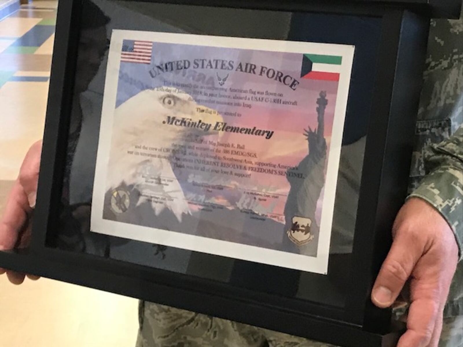 Air Force Maj. Joseph Ball brought an American flag, framed along with this certificate, to students at McKinley Elementary in Xenia who wrote him letters while he was in Iraq. (Gabrielle Enright/Staff)