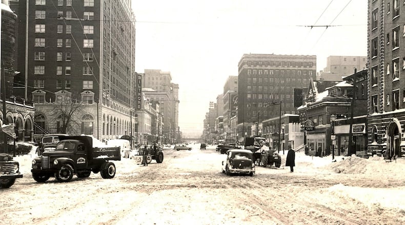 Vehicles and pedestrians attempt to navigate Main St. in downtown Dayton after nearly a foot of snow fell across the region after Thanksgiving Day in 1950. DAYTON DAILY NEWS FILE