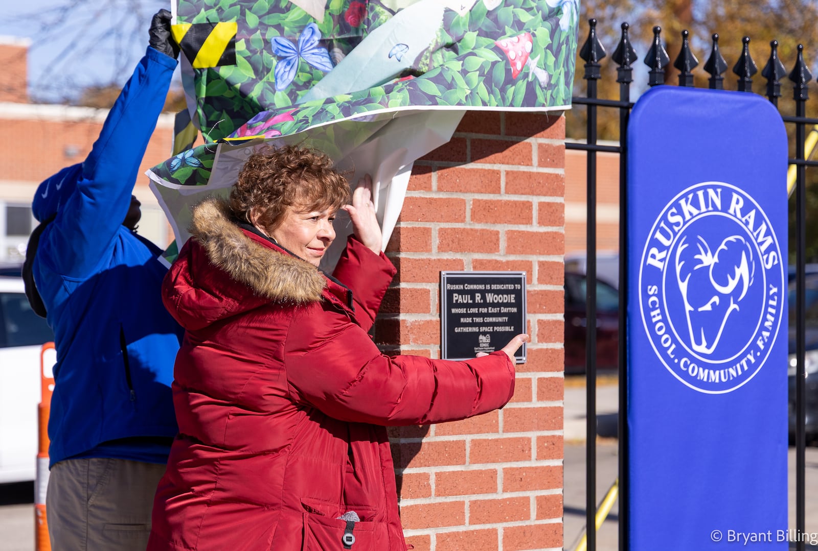 Jan Lepore-Gentleson, the director of East Dayton Neighborhood Development Corporation, unveils a plaque dedicating Ruskin Commons to Paul Woodie during a ribbon cutting ceremony on Wednesday, Nov. 12 in Dayton. Woodie is the EDNDC board president. The new park is located in front of Ruskin Elementary School off Xenia Avenue. BRYANT BILLING/STAFF