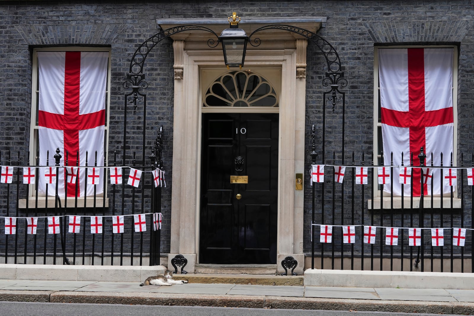 Larry, the cat, Chief Mouser to the Cabinet Office, rests outside 10 Downing Street, decorated for a special reception for England's soccer players to celebrate their victory in the Women's Euro 2025 final, in London, Monday, July 28, 2025.(AP Photo/Kirsty Wigglesworth)