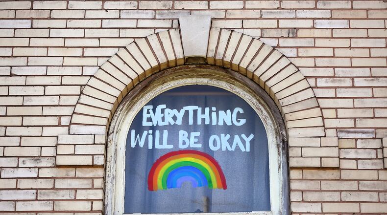 “Everything Will be Okay,” fills a window of an apartment building on West Grand Avenue in Dayton. LISA POWELL / STAFF