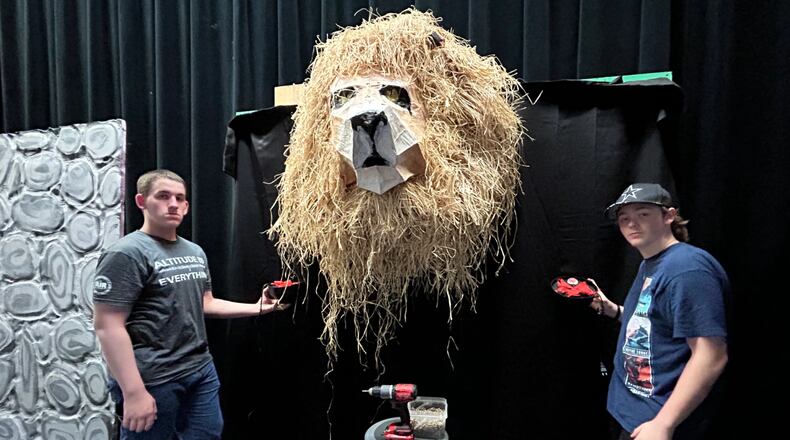 Konnor Porter, who portrays Uncle Fester, and crew member James Powell install prop torches to one of the sets for Springfield High School Wildcat Theatre production of the musical comedy "The Addams Family" at the John Legend Theater, Thursday through Saturday. CONTRIBUTED
