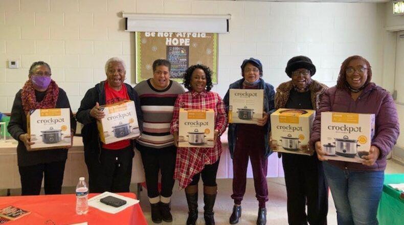 Eva Wells, third from left, also known as "The Crock Pot Lady" gives away crock pots to community members in her crock pot cooking classes.