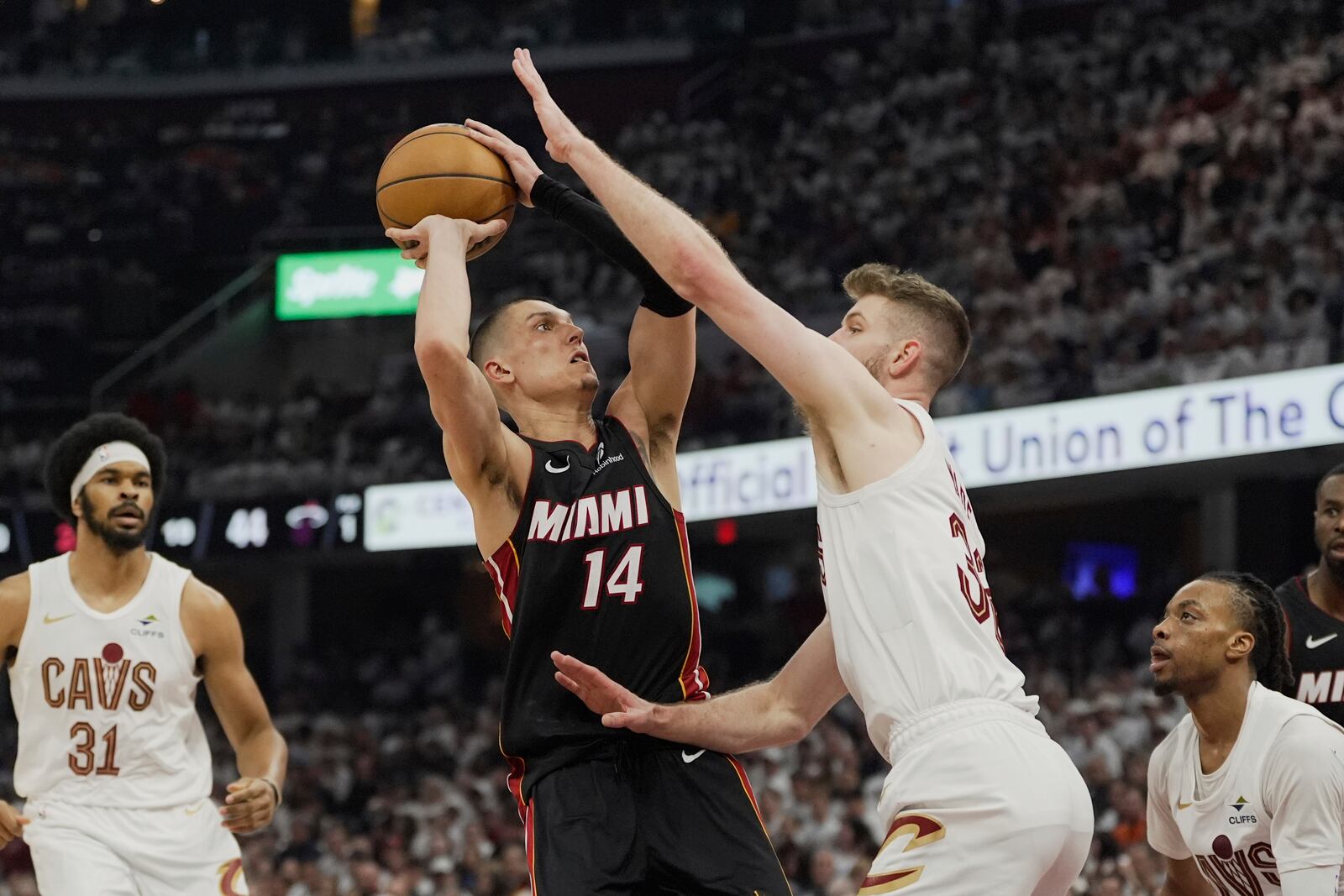 Miami Heat guard Tyler Herro (14) is defended by Cleveland Cavaliers forward Dean Wade, right, in the first half in Game 2 of an NBA first-round playoff series, Wednesday, April 23, 2025, in Cleveland. (AP Photo/Sue Ogrocki)