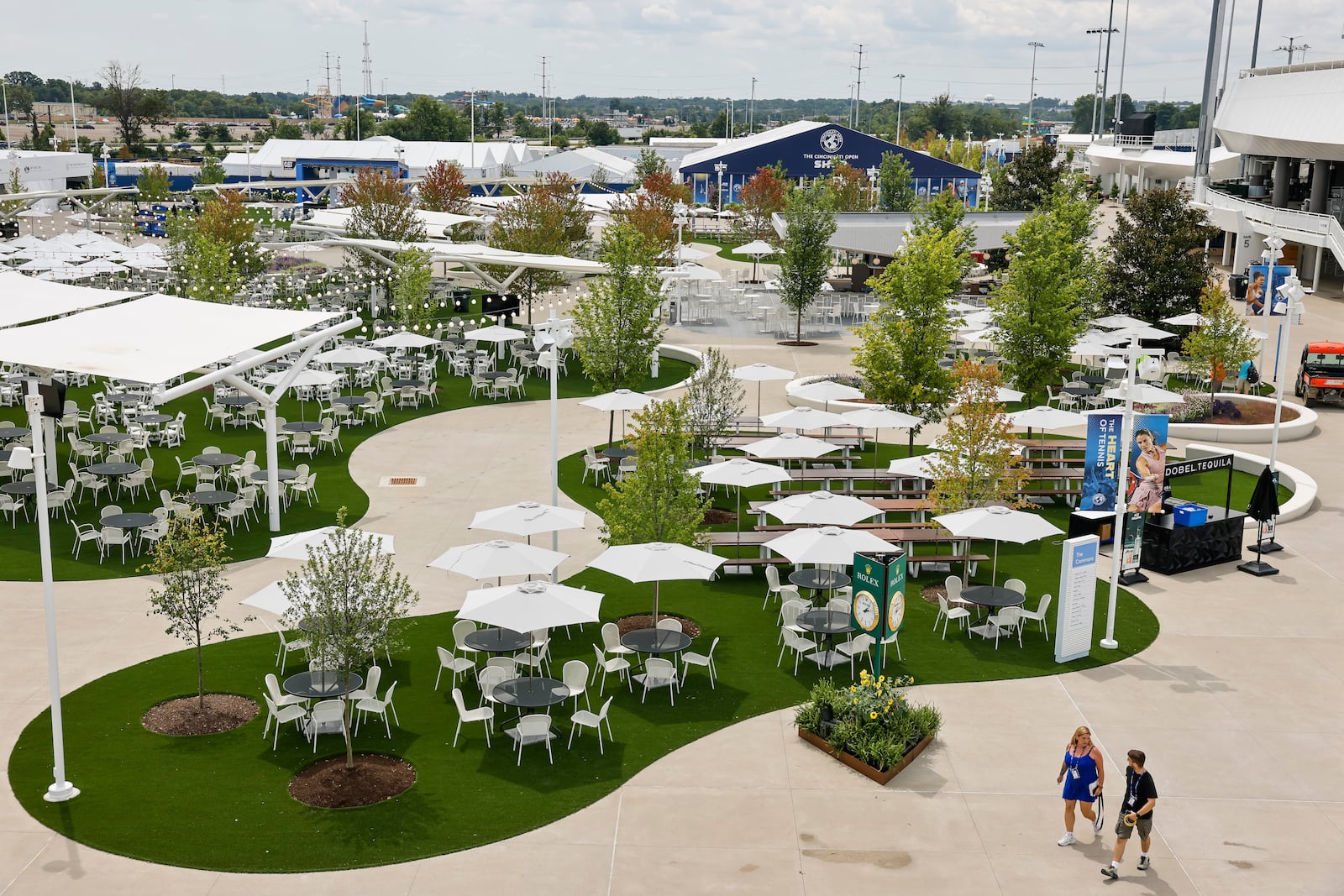 The Lindner Family Tennis Center in Mason, home of the Cincinnati Open, has undergone a $260 million renovation to double the size of the campus to 40 acres, increase amenities for fans and players, add 10 new sunken practice courts with better views for fans and more. The expanded Commons area has seating for 1,400 people with tables and umbrellas near the food court. NICK GRAHAM/STAFF 