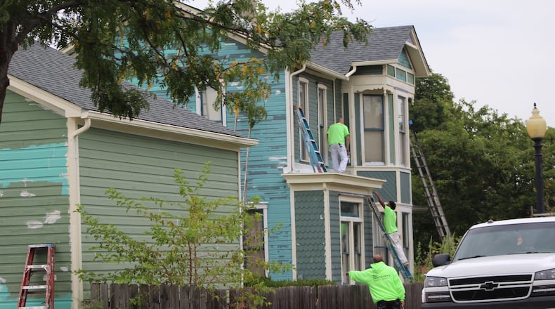 Crews on Friday worked on renovating a home in the Wright Dunbar Village neighborhood. CORNELIUS FROLIK / STAFF