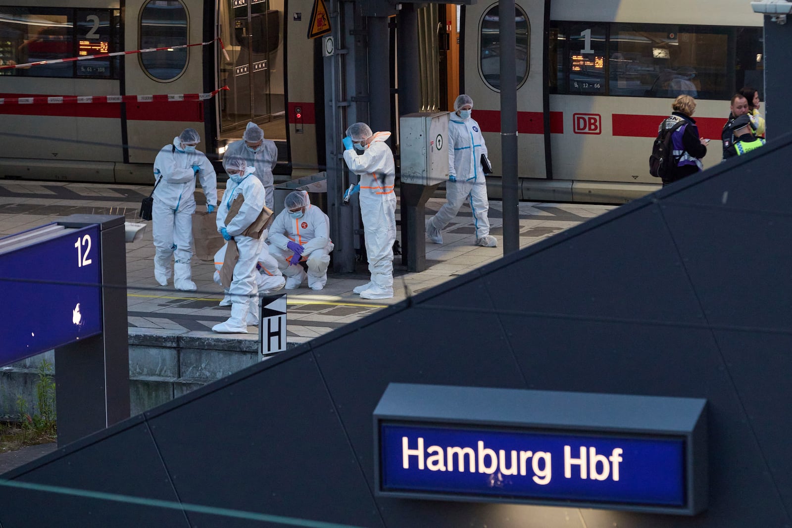 Investigators work at Hamburg, Germany's Central Station on Friday, May 23, 2025, after several people were injured in a knife attack. (Georg Wendt/dpa via AP)