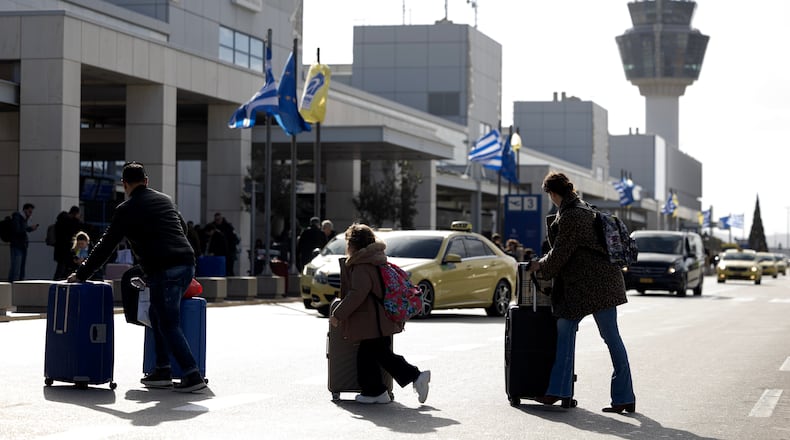 Passengers make their way to Athens' Eleftherios Venizelos international airport in Athens, Greece, Sunday, Jan. 4, 2026, as many flights were disrupted across Greece. (AP Photo/Yorgos Karahalis)
