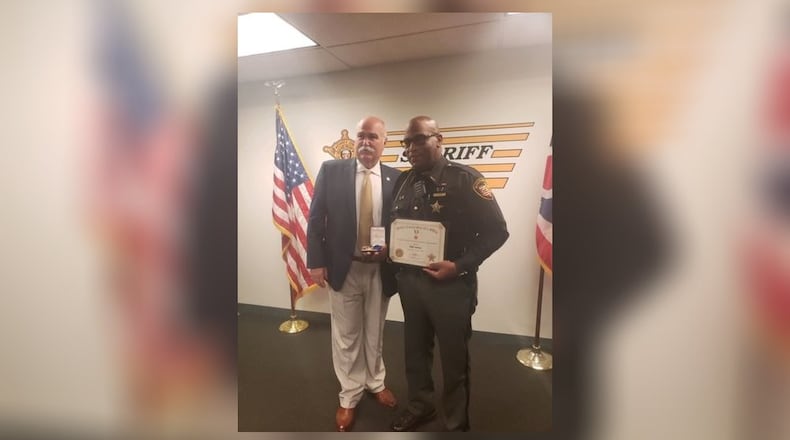 Butler County Sheriff Richard Jones presents Deputy Jody Green with a life-saving award for his quick action to help a choking student. SUBMITTED