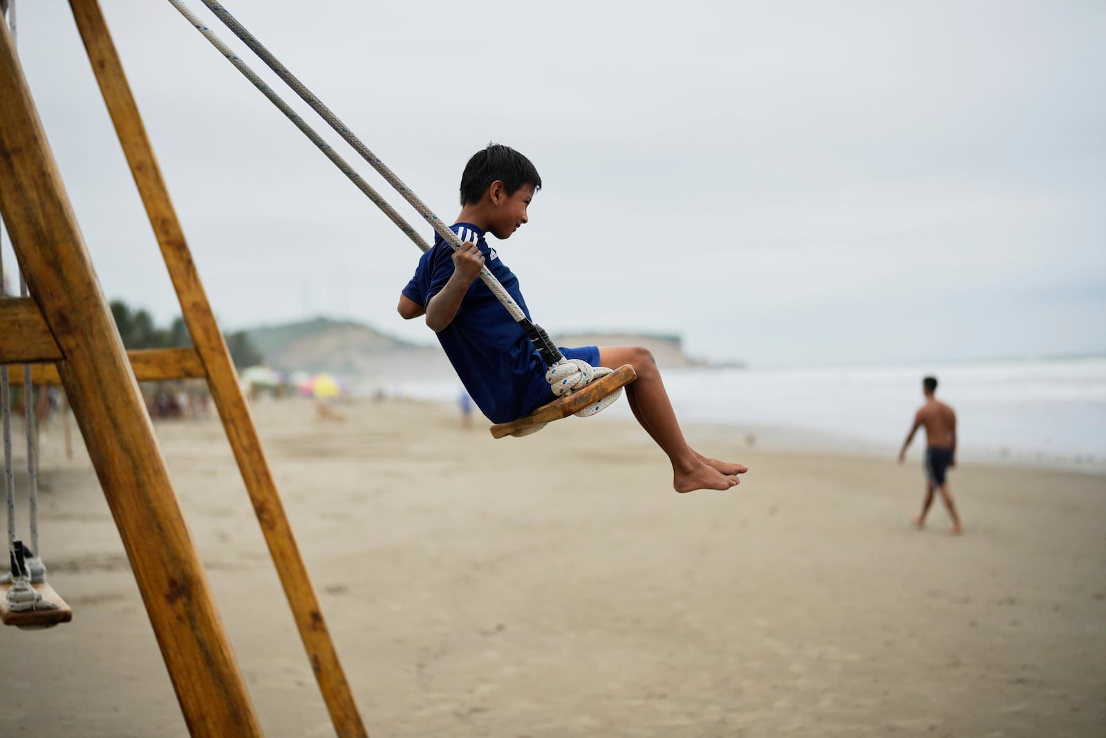 A boy swings on the beach in Olon, Ecuador, during the presidential election runoff, Sunday, April 13, 2025 (AP Photo/Fernando Vergara