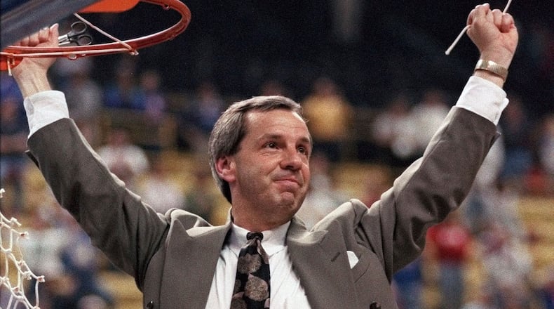 FILE - In this March 27, 1993, file photo, Kansas coach Roy Williams raises his arms in victory after cutting a piece of the net after the NCAA Midwest Regional final in St. Louis. Williams' Jayhawks defeated Indiana 83-77 to advance to the Final Four in New Orleans. Williams paid tribute Wednesday, Sept. 9, 2020, to Gene Budig, a day after the former American League president and head of three major universities died at 81. “He was the guy that gave Roy Williams a chance,” Williams told The Associated Press. “He made it OK for the athletic director to hire this no-name assistant coach from North Carolina as the head basketball coach at the University of Kansas.” (AP Photo/Seth Perlman, File)