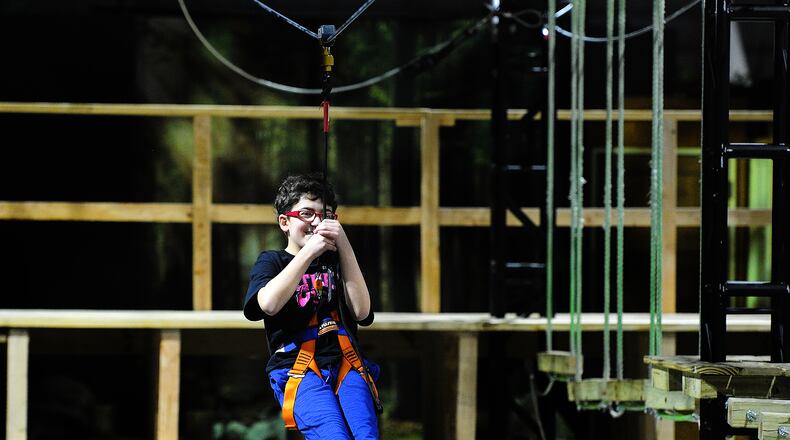 The new exhibit has two sides one is a walk-through, interactive gallery with nine “zones,” each devoted to a different environment or scenario the other is an Adventure Zone Ropes Course and Zip Line, operated by the Air Force Museum Foundation. Eli Mihelcic, age 12 rides the Zip Line Friday Feb. 17, 2023. MARSHALL GORBY\STAFF