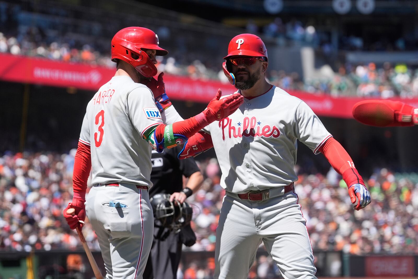 Philadelphia Phillies' Kyle Schwarber, right, is congratulated by Bryce Harper after hitting a three-run home run that also scored J.T. Realmuto and Trea Turner during the eighth inning of a baseball game against the San Francisco Giants in San Francisco, Wednesday, July 9, 2025. (AP Photo/Jeff Chiu)