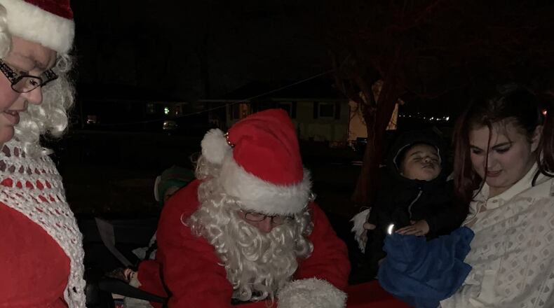 Jason Kingsolver, of Xenia, dressed as Santa, visits Sofia Stump, 2, Zaymeir Jones, 1 and Elias Jones, 3, on Tuesday night at their home in Fairborn. Also pictured is Stephanie Kingsolver, dressed as Mrs. Claus. CONTRIBUTED