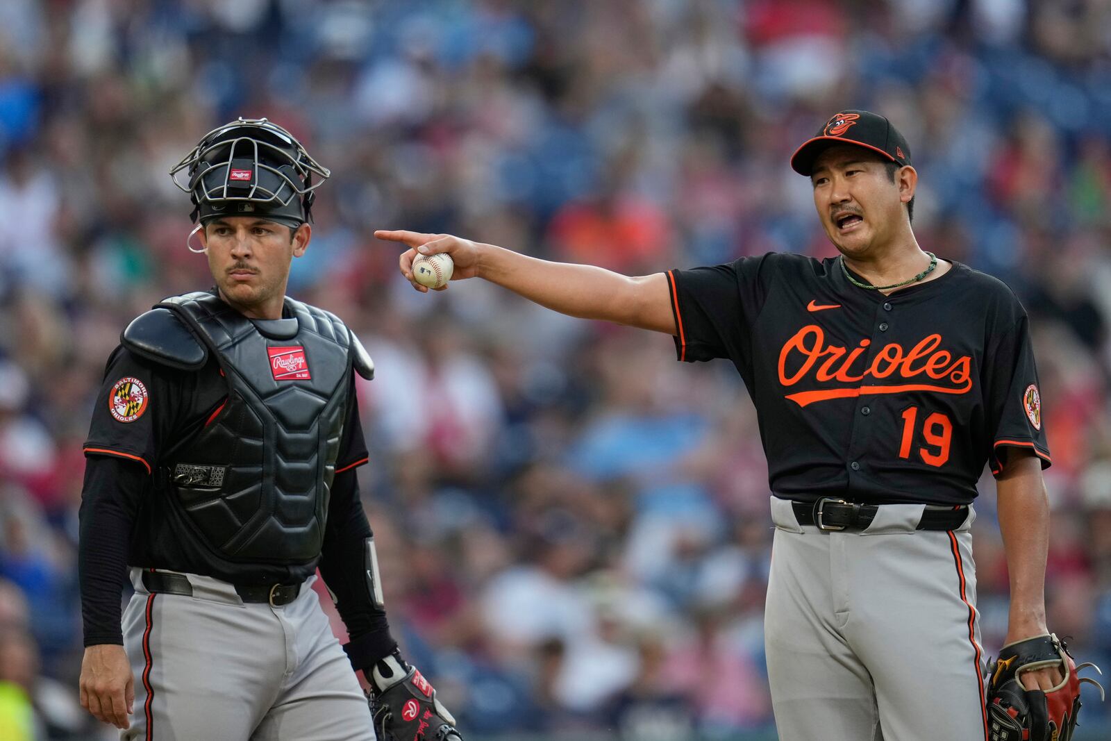 Baltimore Orioles' Tomoyuki Sugano (19) gestures in front of catcher Alex Jackson, left in the fourth inning of a baseball game against the Cleveland Guardians in Cleveland, Monday, July 21, 2025. (AP Photo/Sue Ogrocki)