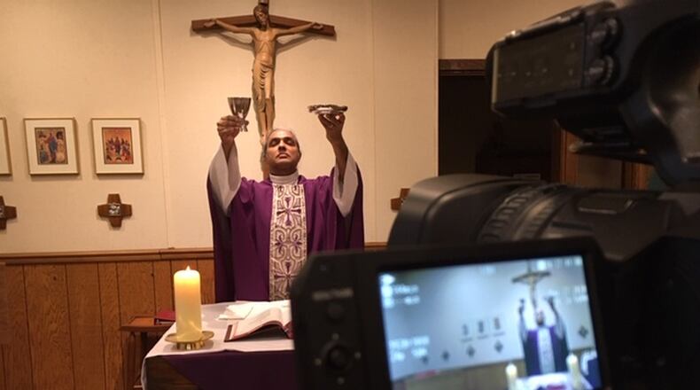 Father Satish Joseph, pastor of Our Lady of the Immaculate Conception and St. Helen in Belmont, livestreams the celebration of Mass at 9 a.m. Monday through Saturday and 10 a.m. Sundays. Typically, there are only two people in the chapel with him when he does this. THOMAS GNAU/STAFF WRITER