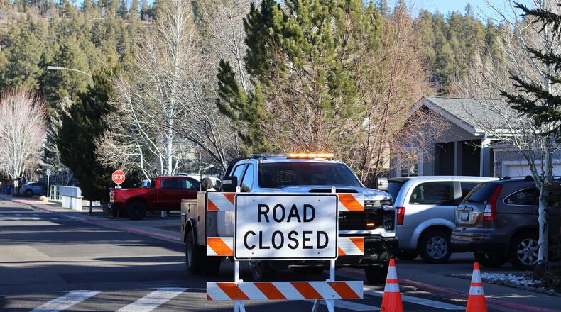The blocked road to a neighborhood in Flagstaff, Arizona, where police say a man opened fire at officers is seen Thursday, Feb. 5, 2026. (AP Photo/Cheyanne Mumphrey)